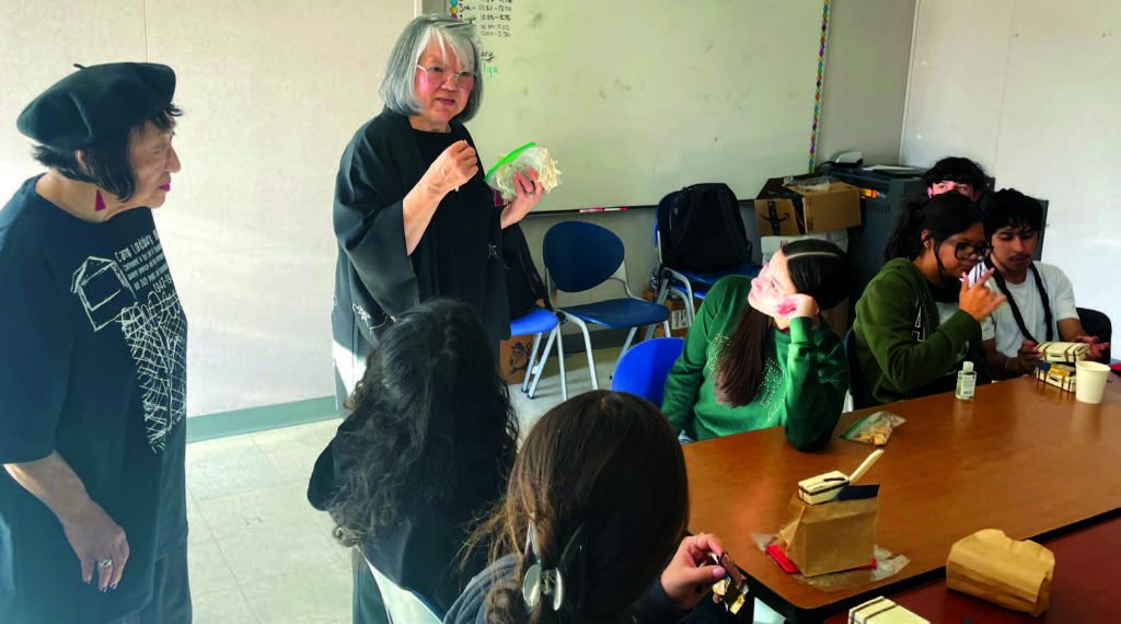 Nikki Nojima Louis, PhD, and Ann Murphy, survivors of Japanese internment camps, teach the cultural practice of origami tohigh school students at New America Charter School.